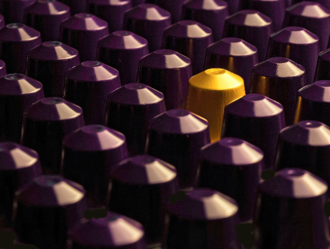 rangées de ca^sules de café violettes dont une jaune