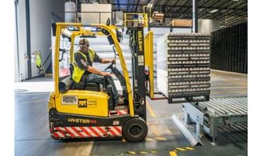 un homme sur une machine servant à transporter des palettes