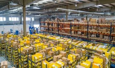 Entrepôt logistique avec rayonnages automatisés et bacs de préparation de commandes