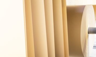 Roll of paper being processed on an industrial production line.