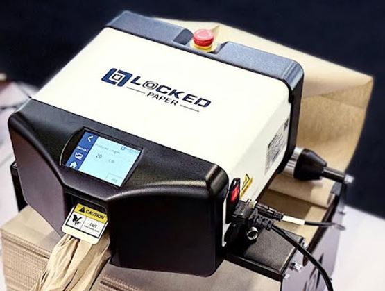 Compact industrial machine branded Locked Paper, featuring a control screen and emergency stop button, converting paper into protective packaging material.