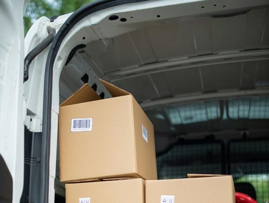 Shipping boxes stacked in the back of a delivery van, ready for shipment or logistical transport.