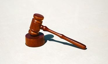 Maillet de juge en bois posé sur une surface claire, symbole de justice et d’autorité juridique.