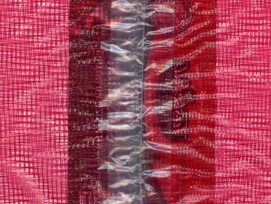 Gros plan sur un matériau plastique rouge tissé avec une bande centrale transparente scellée, révélant la texture et les couches internes du matériau.