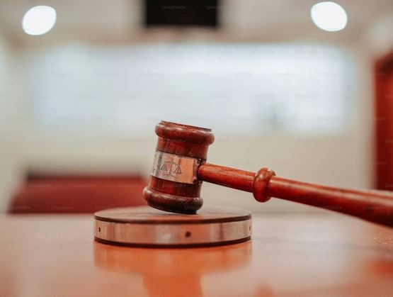 Judge’s gavel resting on its base in a courtroom, symbolizing justice and legal decisions.