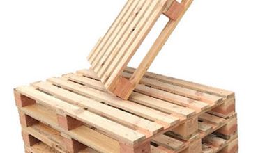 Wooden lid made from recycled pallets, opened on a structure of stacked pallets forming a storage chest or furniture piece.