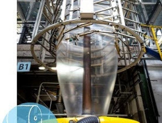 Équipement industriel avec une gaine transparente au centre d’une structure métallique.