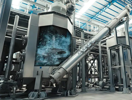 Industrial processing equipment with a large operating tank, metal piping and an inclined screw conveyor.