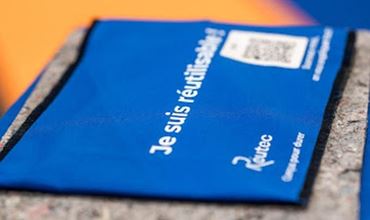 Pochette bleue France Travail posée sur un comptoir, avec le texte « Je suis régulièrement… » visible.