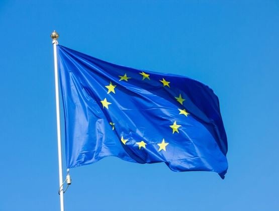 European Union flag waving against a clear blue sky.
