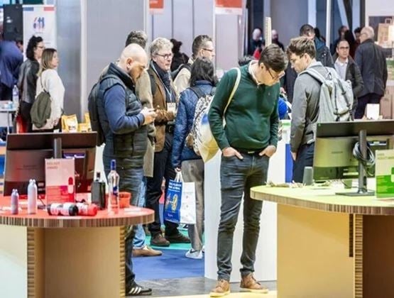 Visiteurs découvrant les stands exposants et les présentations de produits sur un salon professionnel.