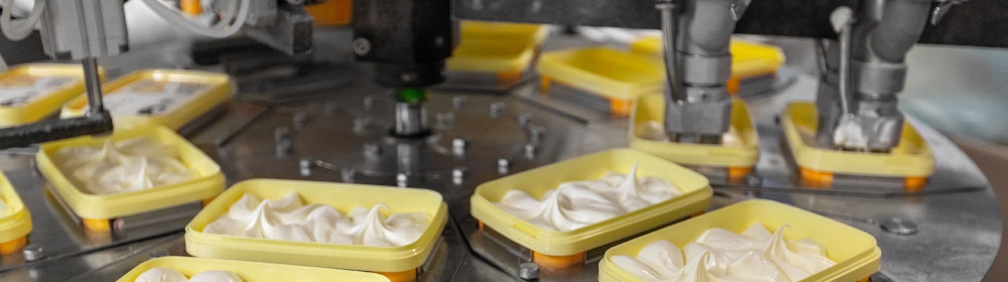 une machine qui met de la mousse alimentaire dans une boite