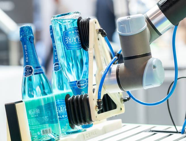 Robot industriel portant des bouteilles