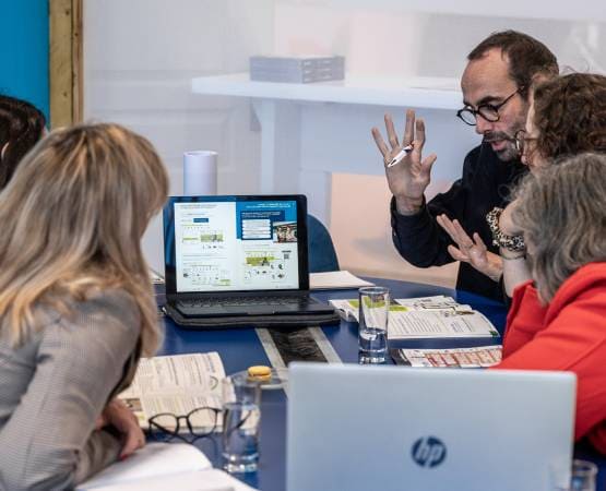 People talking around a computer